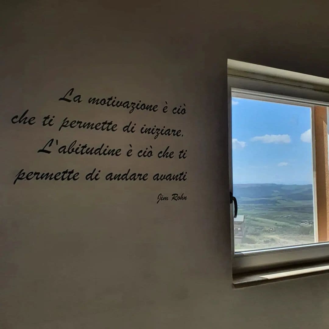 Frase sulla parete: «La motivazione è ciò che ti permette di iniziare. L'abitudine è ciò che ti permette di andare avanti.»